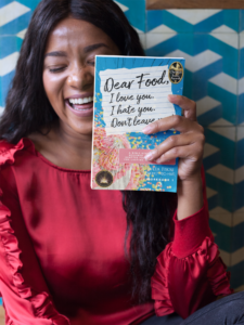 Happy woman holding a Dear Food Workbook